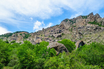 Fototapeta na wymiar Panorama of mountains with huge multi-ton boulders scattered around. Most small of them have height more than 12 feet. Shot in Valley of Ghosts, near Alushta, Crimea