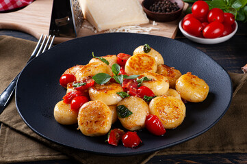 Artisan gnocchi stuffed with cheese, with cherry tomatoes, garlic, olive oil and basil