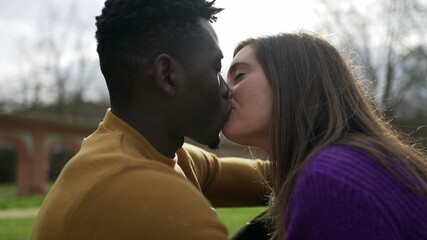 Young interracial couple kiss. Millennial lovers, African and white couple