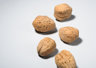 Five large walnuts on a gray background