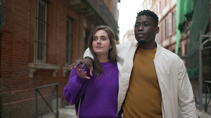 Obraz premium Young interracial couple walking together, modern millennial boyfriend and girlfriend in street