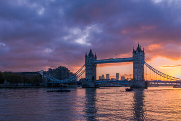 London's Tower Bridge illuminated by a fiery sunrise, with Canary Wharf in the background