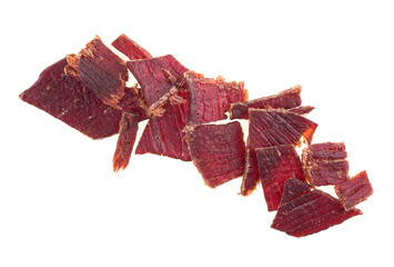 Portion of sliced and dried meat isolated on a white background, top view. Pile of beef jerky...