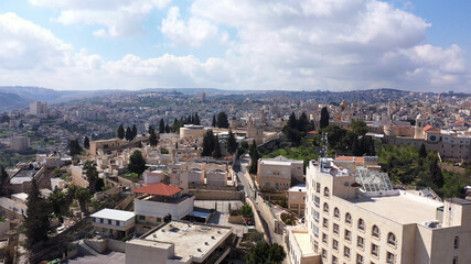 Fototapeta na wymiar Arial view over Church of the Nativity And City Square Of Bethlehem , Morning shot from Bethlehem, the town where Jesus was born. Place of The Church of the Nativity 