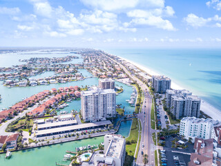 Fototapeta premium Island in Gulf of Mexico. Ocean or shore. Spring break or Summer vacations in Florida. Hotels, restaurants and Resorts. Tropical Nature. Clearwater Beach FL. Aerial view.