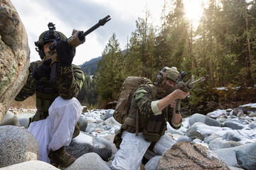 Army Man wearing Tactical Uniform and holding Machine gun in the Outdoor Rain Forest. Winter Warfare. Taken in British Columbia, Canada.