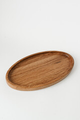 Wooden plate with an oval shape on a white background. Wooden utensils on white background.