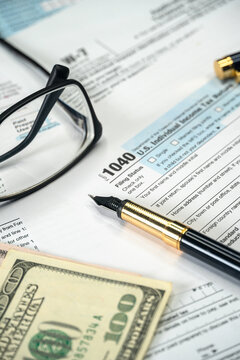 Filling US tax form 1040. Tax time for USA business income return tax and irs. Vertical photo