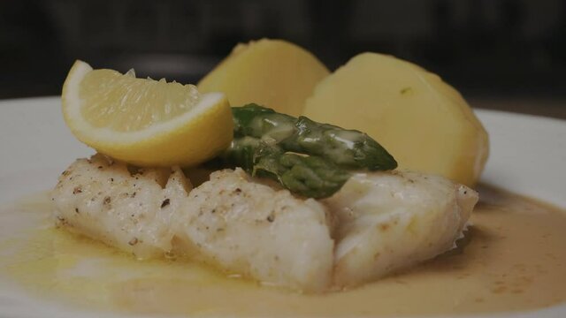 Serving white cod fish on a restaurant