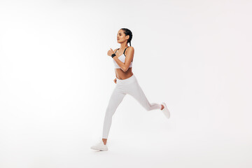 Fototapeta na wymiar Fitness woman in sportswear running over white background in studio