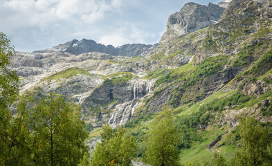 A cascade of waterfalls on the mountainside in the middle of the forest .