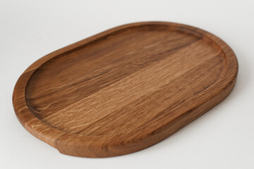 Comfortable wooden tray on a white background. Dishes made of ash wood. Wooden utensils.