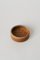 Small round wooden bowl for nuts on a white background. Wooden dishes with their own hands.