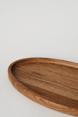 Half wooden plate on a white background. Oval shaped plate made of wood.