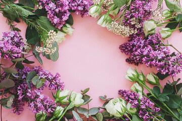 Beautiful lilac and roses colorful frame on bright pink background, flat lay with space for text