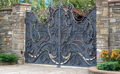 Large forged private brown gray metal gates on a city street