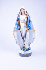 Statue of Virgin Mary with rosary on neck on white background