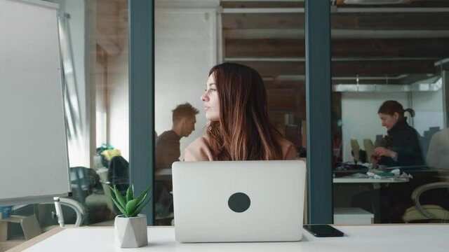 Woman works In The Office For A Laptop, Rejoices Perfectly Done Work.