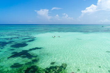young people playing volley-ball in huge turquoise lagoon at Zanzibar, Tanzania.