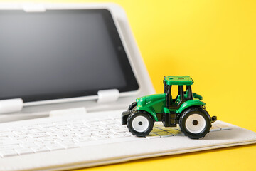 Naklejka premium Concept of using modern technologies and artificial intelligence in agriculture. Tractor and gadget on yellow background. Autonomous Farm Equipment and Tractors. Copy space