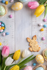 Happy easter background with bunnies, eggs, candies flowers