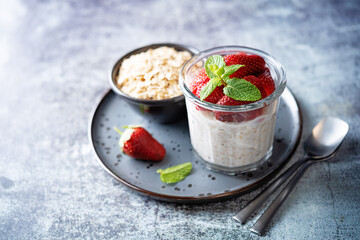 Oatmeal porridge with milk and fresh strawberries in a glass