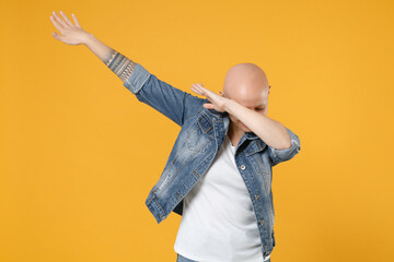 Young bald caucasian woman 20s without hair in casual denim jacket white t-shirt doing dab hip hop...