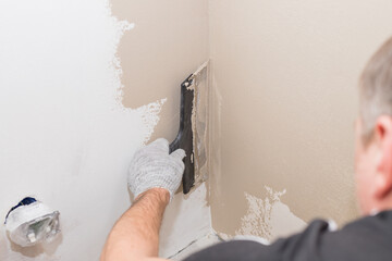 hand of builder worker plastering at wall.Renovation workers hand plastering the wall.Construction...