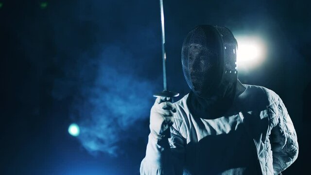Male fencer in a mask is ready to attack