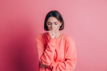 Woman wearing casual sweater on background feeling unwell and coughing as symptom for cold or bronchitis. Healthcare concept.