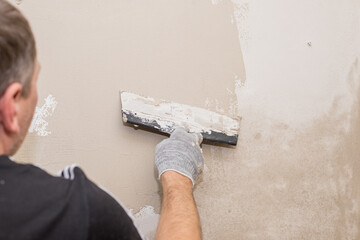hand of builder worker plastering at wall.Renovation workers hand plastering the wall.Construction...