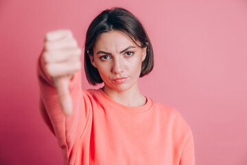 Woman wearing casual sweater on background looking unhappy and angry showing rejection and negative with thumbs down gesture. Bad expression.