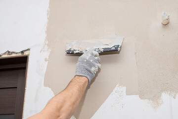 hand of builder worker plastering at wall.Renovation workers hand plastering the wall.Construction...