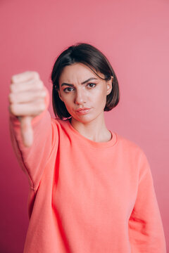 Woman wearing casual sweater on background looking unhappy and angry showing rejection and negative with thumbs down gesture. Bad expression.