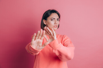 Woman wearing casual sweater on background disgusted expression, displeased and fearful doing disgust face because aversion reaction