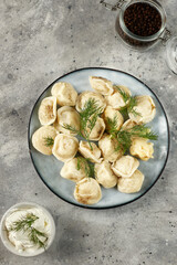 Homemade handmade dumplings, organic from farm meat with herbs and sauce, Russian national cuisine
