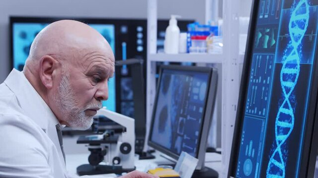 Elderly professor is doing a science experiment in a modern laboratory. Genetic engineers workplace. The concept of science, medicine and vaccine development.