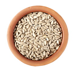 Peeled sunflower seeds in clay pot isolated on white background, top view