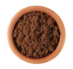 Muscovado sugar in clay bowl isolated on white background, top view