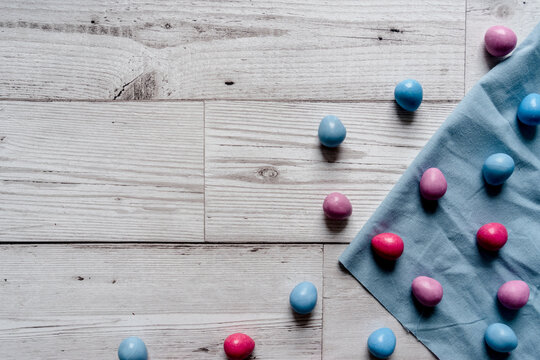 Overhead Shot Of Colorful Blue, Pink, And Purple Chocolate Easter Egg Candy On White Wooden Background