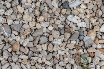 Colorful small pebbles. gravel texture on the background. Texture of little rocks. Small stones, little rocks, pebbles in many shades of grey, white, brown, yellow colour.