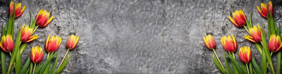 Red and yellow tulips on wooden background top view