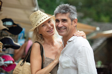 happy senior couple of tourists with map