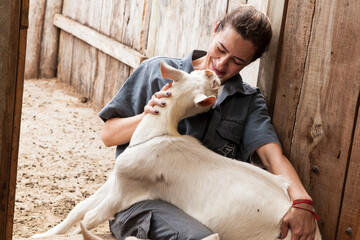 Veterinária faz carinho em cabra demostrando todo seu amor pela profissão.