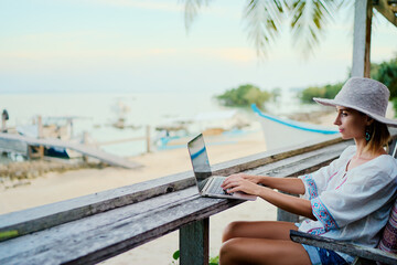 Technology and travel. Working outdoors. Freelance concept. Pretty young woman using laptop in cafe...