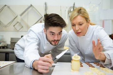 chef and assistant prepare delicious chocolates eggs in the kitchen