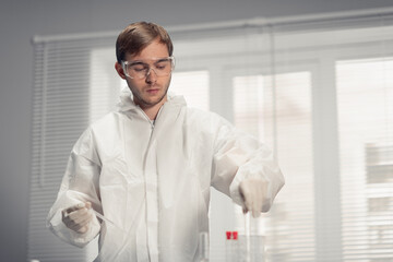 Fototapeta premium Young male scientist preparing to load the analyzer with samples in laboratory.