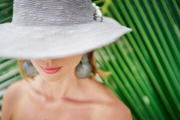 Vacation and natural beauty. Close up outdoor portrait of tanned young woman in hat.