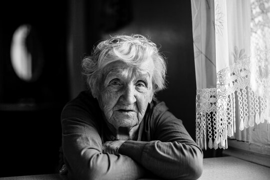 An old woman portrait in her house. Black and white photo.