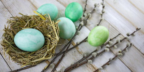 image of festive easter eggs and willow branches on a wooden table